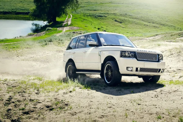 Car Land Rover Range Rover is driving at sand countryside road — Stock Photo, Image