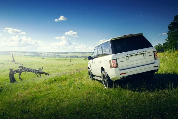 Car Land Rover Range Rover está de pie en el prado de hierba verde en el día de verano — Foto de Stock