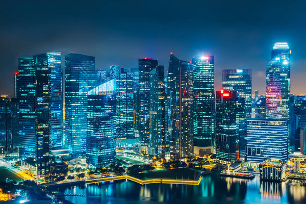 Singapore city skyline. Business district aerial view. Downtown landscape reflected in water at night in Marina Bay. Travel cityscape