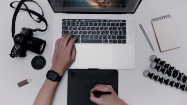 Adam dizüstü bilgisayar ve grafik tablet çalışıyor. Üstten Görünüm Tasarımcısı düz yatıyordu