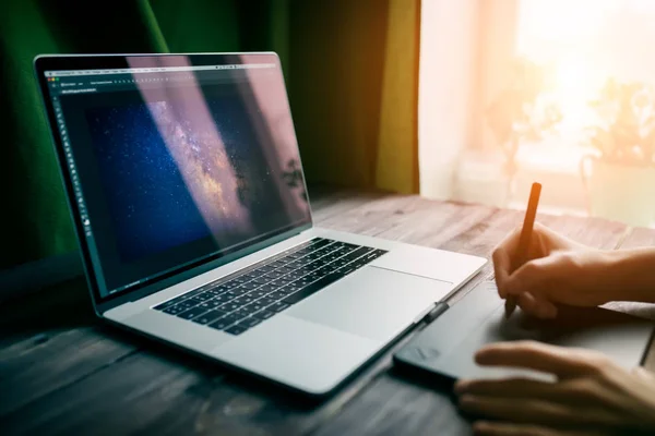 Man freelancer werkt met behulp van laptopcomputer en grafische tablet thuis kantoor. Professionele bezetting werkplek — Stockfoto