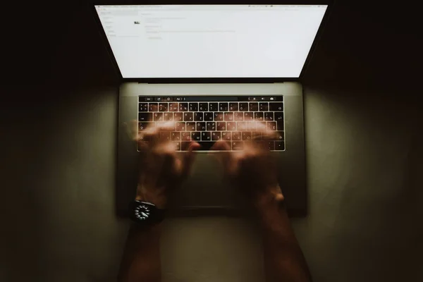 L'uomo sta lavorando digitando utilizzare il computer portatile durante la notte scura. Scrittore piatto lay vista dall'alto sul posto di lavoro — Foto Stock
