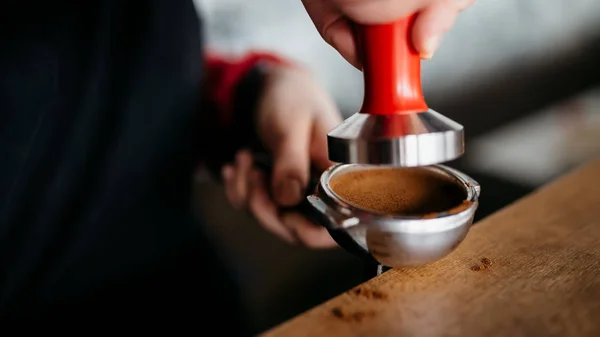 Barista está se preparando para fazer café com temperamento nas mãos — Fotografia de Stock