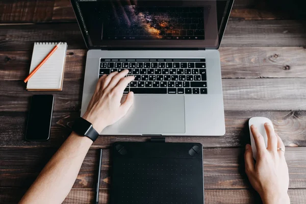 Uomo designer sta lavorando utilizzando computer portatile e tablet grafica a casa — Foto Stock