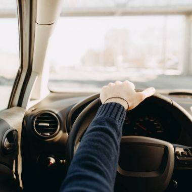 Adam araba kullanıyor. İç iç görünüm. Direksiyon simidi ellerde