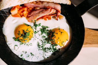 Kızarmış yumurta, pastırma, domates, kızarmış ekmek. Klasik kahvaltı gıda demir Pan