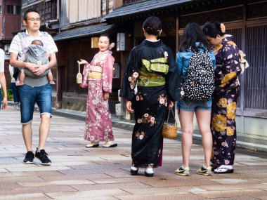 Kanazawa, Japonya - 29 Eylül 2015: Renkli kimonolu Asyalı kadınlar Higashi chaya tarihi geyşa bölgesinde fotoğraf çekiyorlar