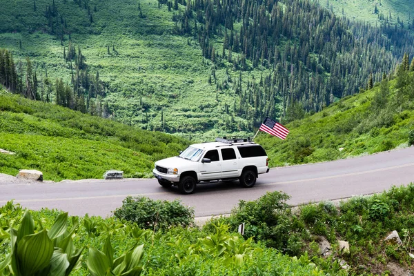 Buzul Ulusal Parkı, ABD - 4 Temmuz 2016: Ulusal bayramda Güneşe Giden yolda Amerikan bayrağı taşıyan otomobil
