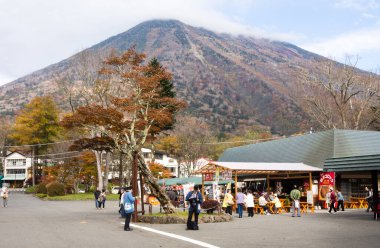 Nikko, Japonya - 25 Ekim 2016: Arkaplanda Nantai Dağı ile ünlü Kegon Ulusal Parkı girişindeki hediyelik eşya tezgahları ve gıda satıcıları