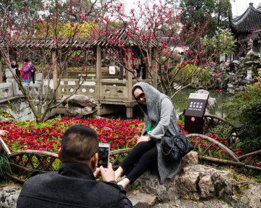 Suzhou, Çin - 23 Mart 2016: Suzhou 'daki bir Unesco Dünya Mirası sahası olan Lion Grove bahçesinde kiraz çiçekleriyle fotoğraf çeken ziyaretçiler