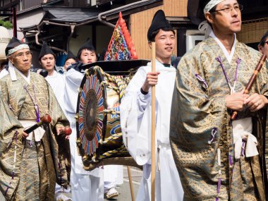 Takayama, Japonya - 10 Ekim 2015: Shinto rahipleri geleneksel Takayama Sonbahar Festivali geçit töreni sırasında Takayama eski kasabasının sokaklarında ritüel bir davul taşıyorlar