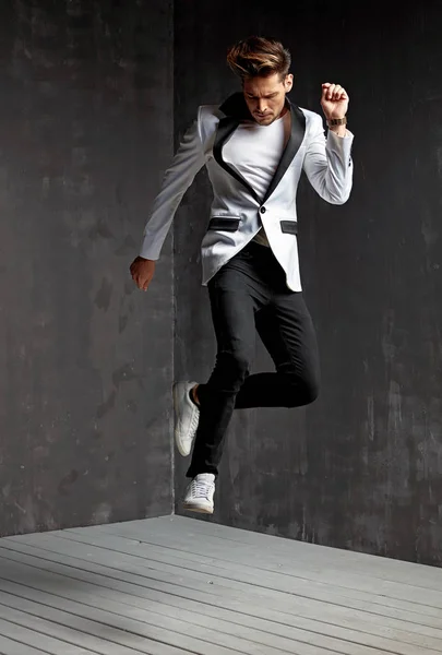 Handsome man dancing on the wooden floor — Stock Photo, Image