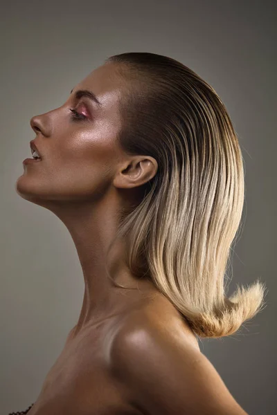 Loira chamring senhora com um moderno coiffure posando em perfil — Fotografia de Stock