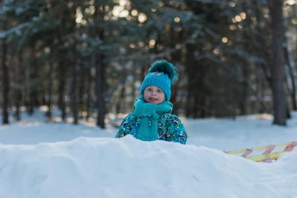 Bella ragazza in abito turchese che gioca con la neve nella giornata invernale — Foto Stock