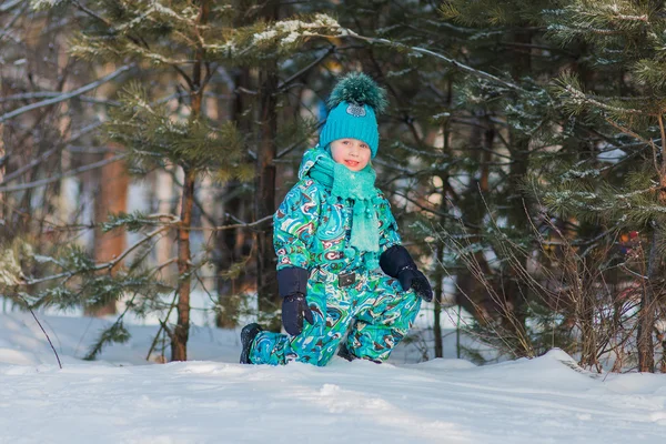 Mooi meisje in een turquoise jurk spelen met sneeuw in de winterdag — Stockfoto