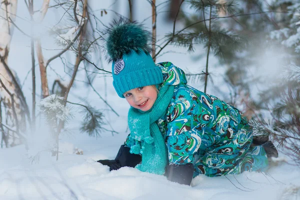 Mooi meisje in een turquoise jurk spelen met sneeuw in de winterdag Stockfoto