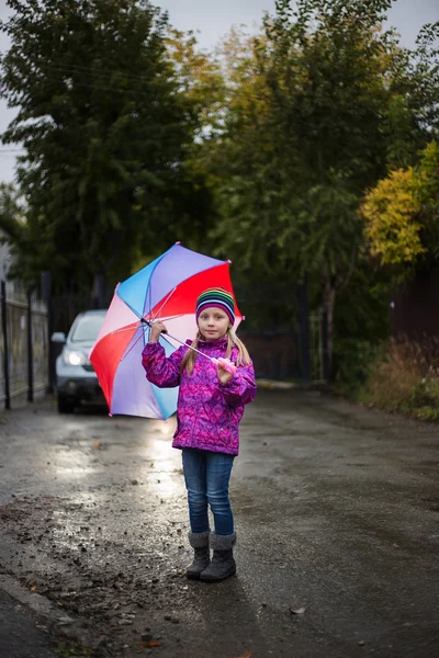 Menina andando na chuva sob um guarda-chuva — Fotografia de Stock