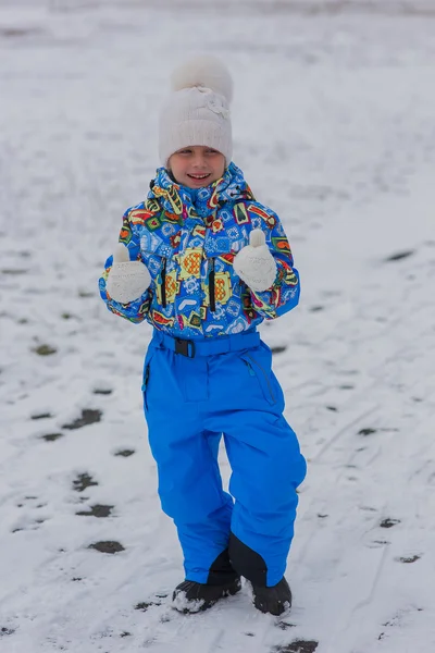 Mädchen läuft Wintertag in Overalls. Erwärmen. — Stockfoto