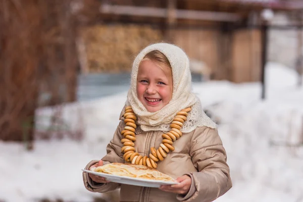 Mädchen am Tag des Karnevals leckt Pfannkuchen — Stockfoto