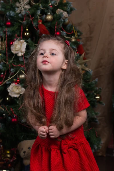 Красивая девушка с длинными волосами в красном платье в праздник Рождества — стоковое фото