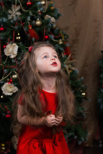 Красивая девушка с длинными волосами в красном платье в праздник Рождества — стоковое фото