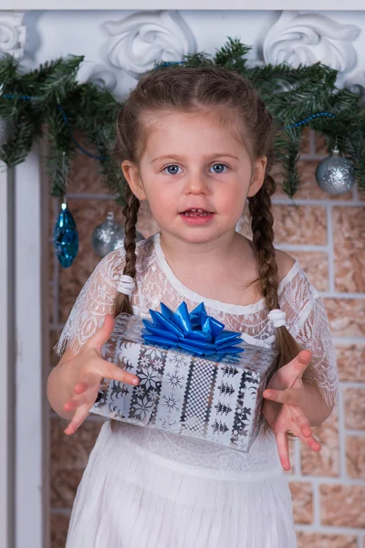 Девушка с двумя косичками с подарком в коробке в новогодний праздник — стоковое фото