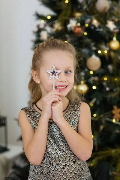 Удивлённая девушка со звездой в рождественской елке — стоковое фото