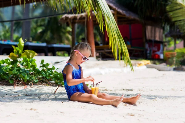 Niña linda en la playa en un traje de baño, gafas de sol, sentado debajo de una palmera, beber cóctel exótico — Foto de Stock