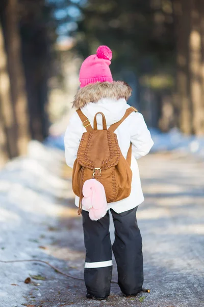 Mädchen mit Rucksack läuft an einem sonnigen Wintertag die Gasse im Park entlang — Stockfoto