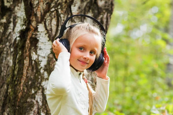 Hermosa niña con auriculares al aire libre —  Fotos de Stock