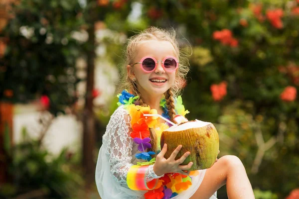 Симпатичная улыбающаяся девушка в солнечных очках, цветочные бусины с кокосовым напитком. Фото с обработкой HDR . — стоковое фото