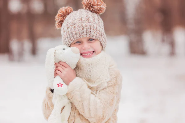 Menina bonito em um chapéu com uma lebre de brinquedo macio favorito — Fotografia de Stock