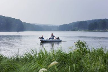 iki çocuk babası tekne ile tatil yaz gününde gölde yüzüyor