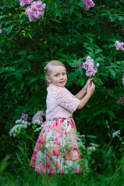 Belle fille mignonne dans le parc d'été avec arbre lilas — Photo