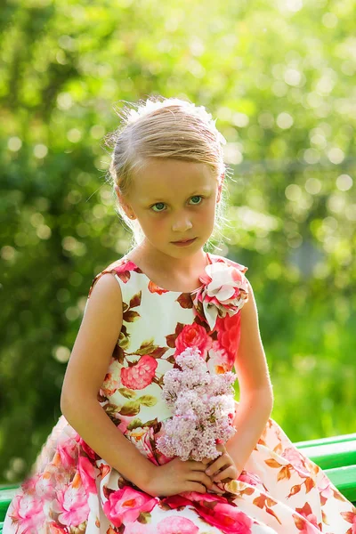 Linda chica hermosa en el parque de verano con ramo de lila al atardecer en la noche — Foto de Stock