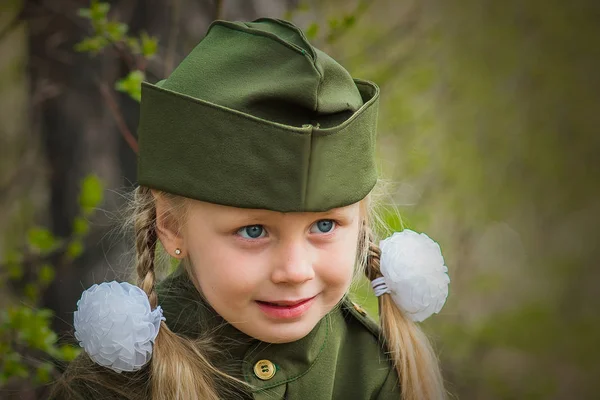 Nettes kleines Mädchen in Mütze und Militäruniform am Feiertag 9. Mai — Stockfoto