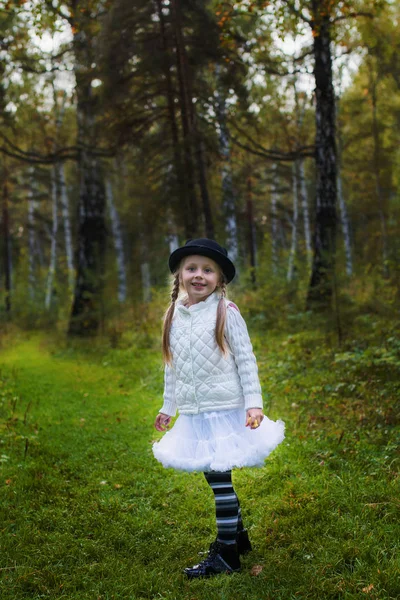 Überraschte kleines Mädchen mit zwei Zöpfen im Hut im Sommermärchenwald — Stockfoto