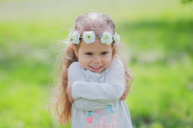 Bir yaz parkta çiçek çelenk, sevimli küçük kız