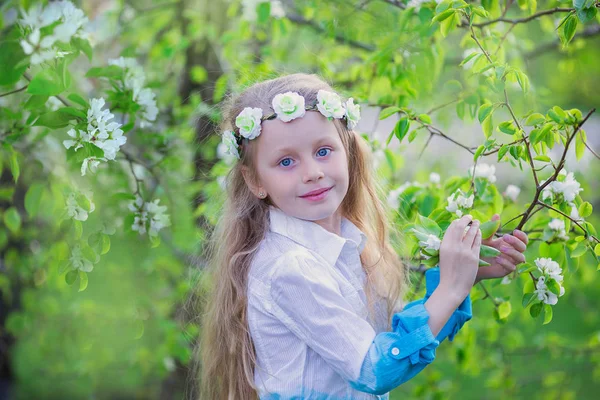 Menina adorável no jardim da macieira florescendo no belo dia de primavera. Criança bonito colhendo flores de maçã fresca no sprin — Fotografia de Stock