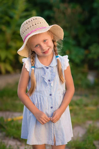 Retrato de menina bonita sorridente em chapéu, contra verde do parque de verão. A olhar para a câmara. Infância. Hora de verão . — Fotografia de Stock