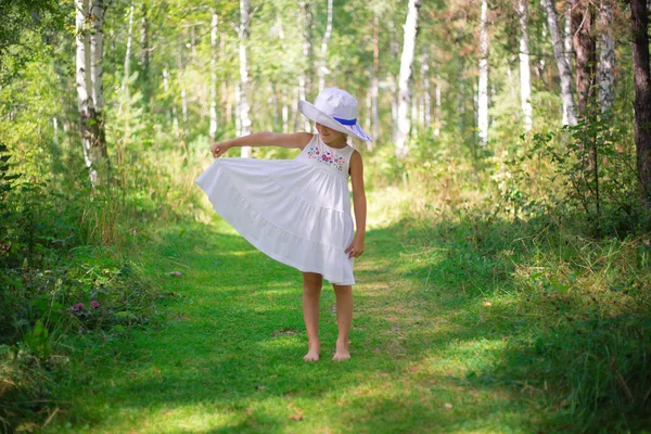 Egy aranyos kis lány a nyári erdei séta. szabadság koncepció fénykép esőerdőkben ealry Ray fények — Stock Fotó