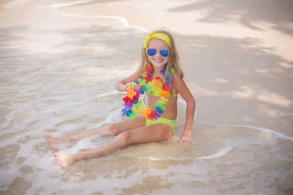 Felice bambina sta nuotando in occhiali da sole colorati sulla spiaggia al mare — Foto Stock