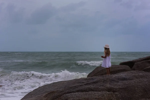 Charmante fille aux cheveux longs marchant au bord de la mer dans la tempête — Photo