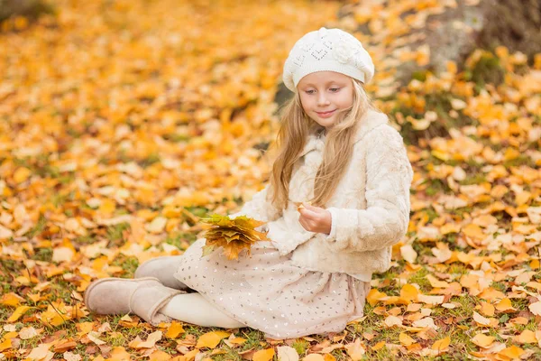 黄色い葉をした少女。秋の紅葉で遊ぶ子供たち。子供たちは公園で屋外で遊ぶ。秋の森をハイキングする子供たち。幼児子供下Aメイプルツリー上のA日当たりの良い10月の日. — ストック写真