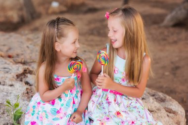 Mutlu kız parkta bir şeker yemek yaz gün.