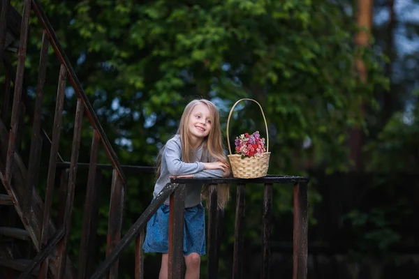 Милая красивая маленькая девочка с корзиной цветов — стоковое фото