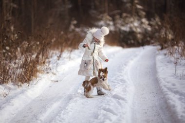 Ormanda köpek ile kış kar günde oynayan kız
