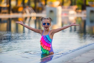 Portre sevimli mutlu küçük kız havuzda eğleniyor. Çocuklar spor aile yaz tatil. Aktif sağlıklı tatil