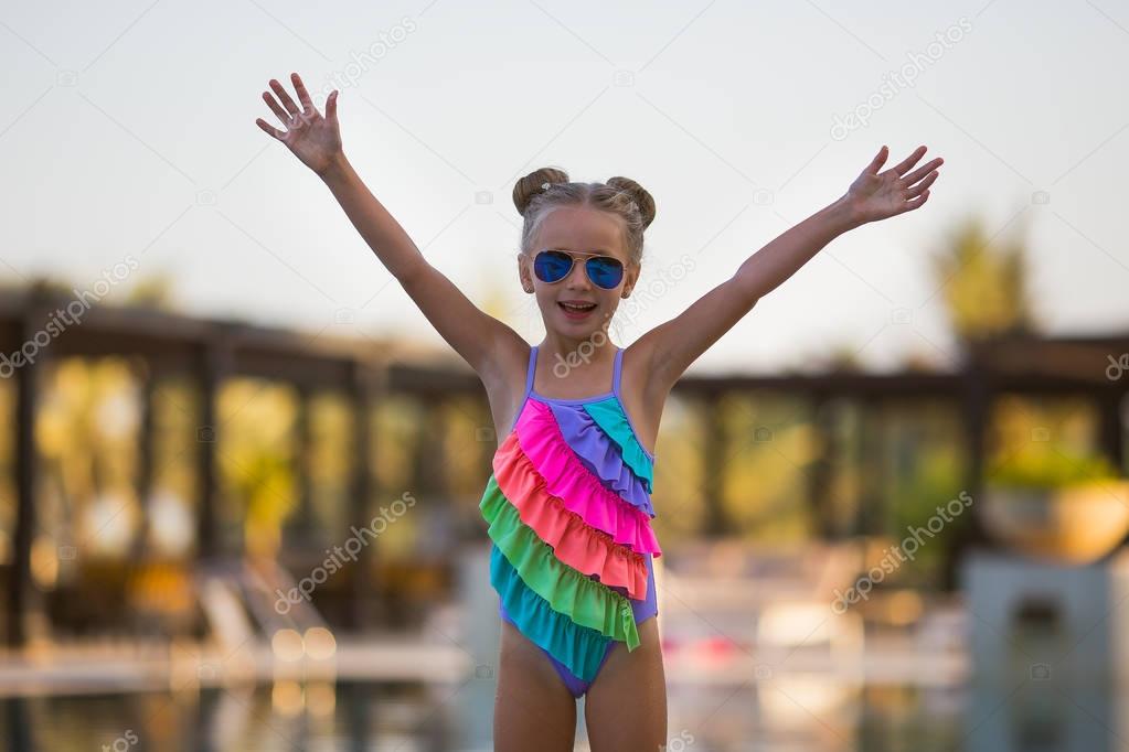 Portrait of cute happy little girl having fun in swimming pool.  Kids sport on family summer vacation. Active healthy holiday