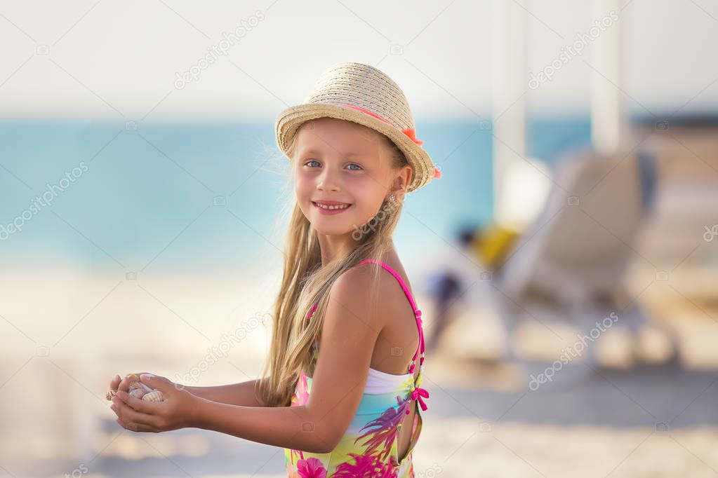 Beautiful girl in a hat on tropical beach vacation